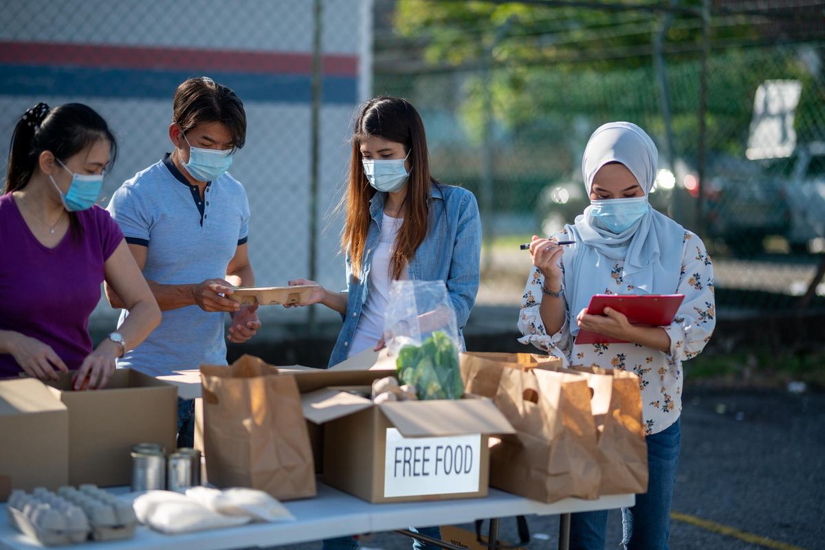 adults packing donation boxes in charity food bank