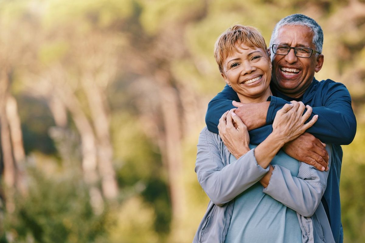 senior couple hugging in a garden while on romantic outdoor date