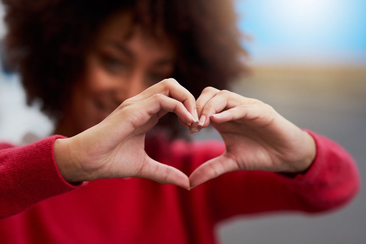 woman forming a heart shape with her fingers