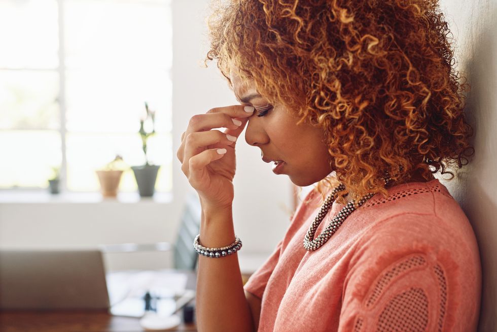 woman suffering from a headache due to Low Progesterone Symptoms