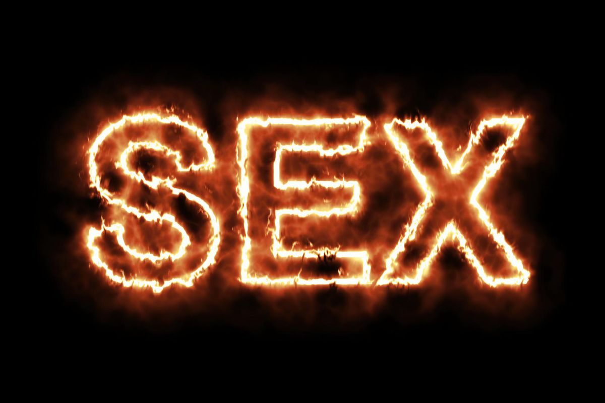 word SEX burning on fire on black background